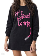 IT'S HARD TO BE ME – vestito in felpa nera con scritta rosa fluo, indossato da una modella – dettaglio della stampa