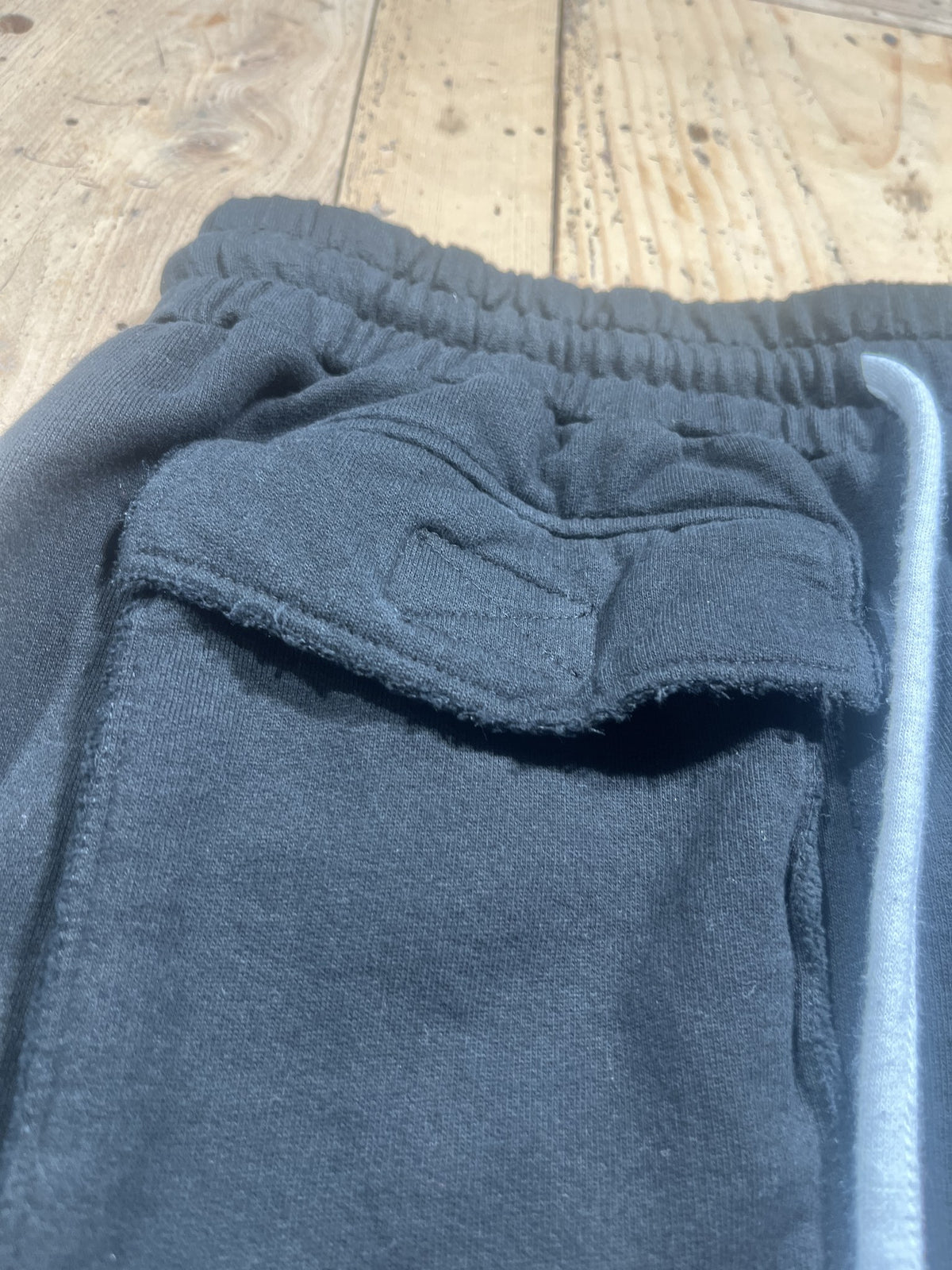 Jogger cargo nero in felpa con coulisse grigia – dettaglio tasca